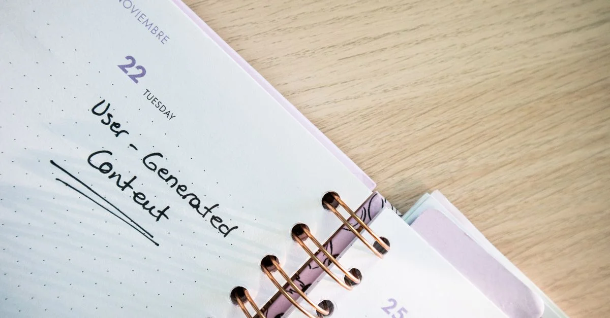 Agenda ouvert affichant une date avec des notes manuscrites sur un bureau en bois.