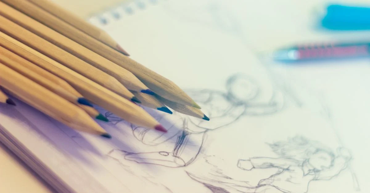 Gros plan sur des crayons de couleur sur un bloc-notes rempli de croquis, parfait pour des concepts de créativité.